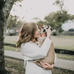 smiling women carrying a dog