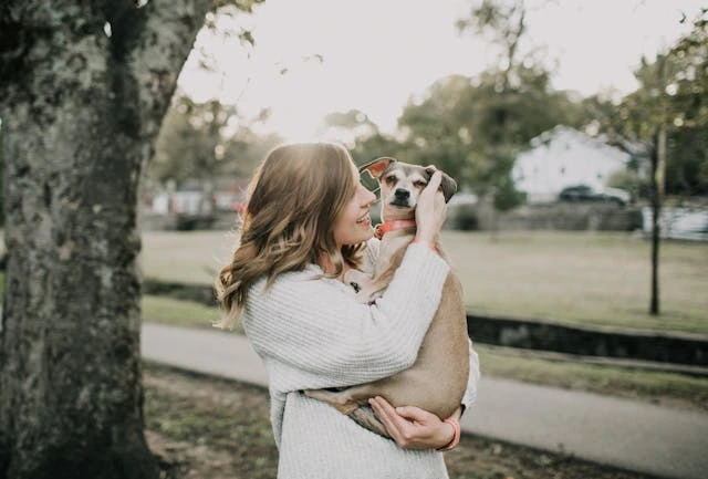 smiling women carrying a dog